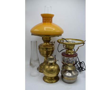 A collection of vintage oil lamps to include brass and pottery examples with associated chimneys and shade, one of which has 