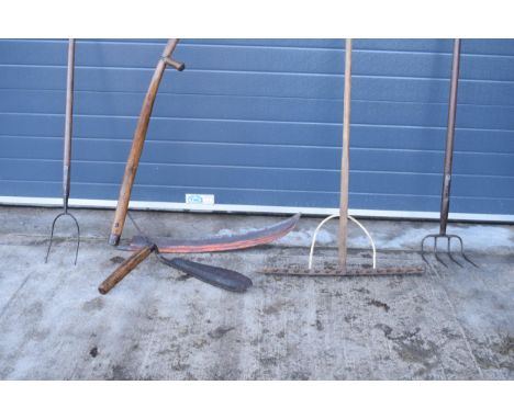 Agricultural interest: a collection of farming and gardening tools to include a wooden hay rake, a scythe, a two-prongue pitc