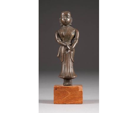   STEHENDE TÄNZERIN     Indien, 18./19. Jh.     Bronze, braun patiniert. Ges.-H. 12,7 cm, H.-Figur: 10,5 cm. Mit beweglichen 