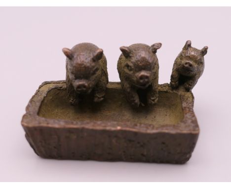 A small bronze model of pigs at a trough. 4.5 cm long.