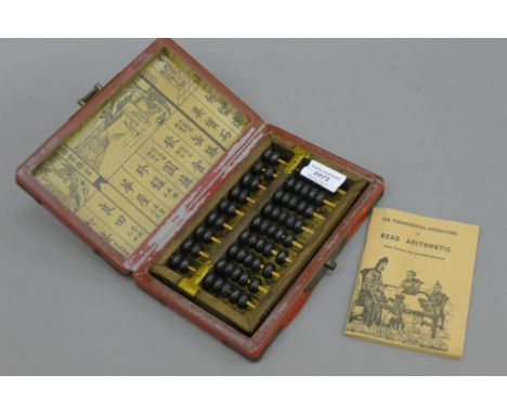A Chinese abacus in a lacquered box. The box 20 cm wide.