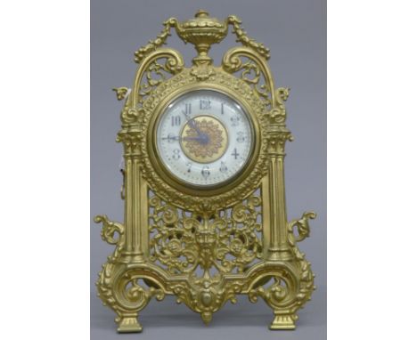 A brass strutt clock. 32 cm high.