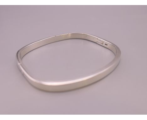 A silver bangle bracelet.  6 cm internal diameter. 