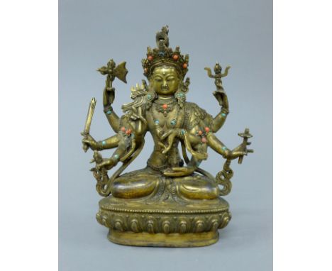 A gilt bronze multi-armed buddha decorated with coral and turquoise. 21.5 cm high.