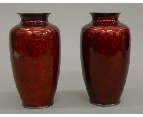 A pair of early 20th century Japanese vases, the clear red enamel revealing and engraved silver body, possibly with Ando Mark