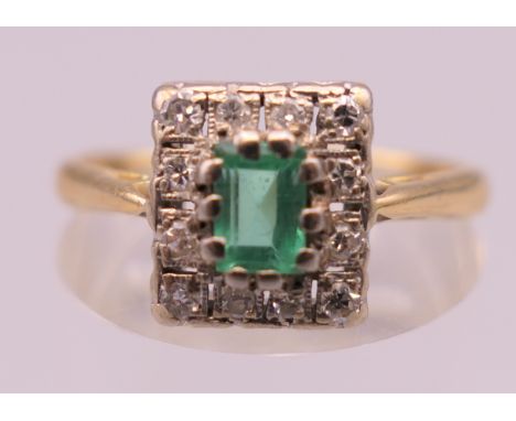 An 18 ct gold emerald and diamond ring. Ring size Q. 3.7 grammes total weight.