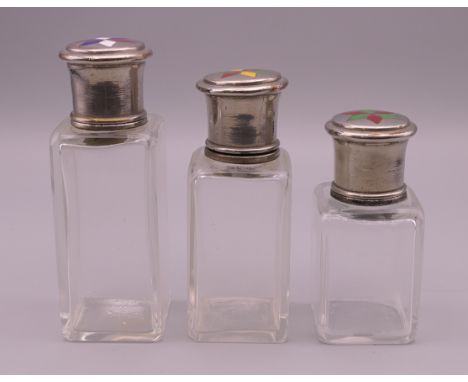 Three enamel decorated dressing table jars.  Tallest 10.5 cm high. 