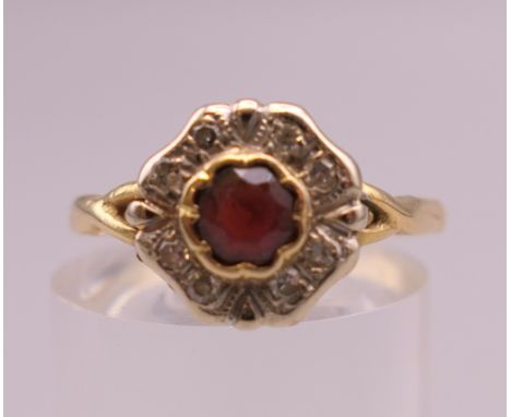 An 18 ct gold diamond and ruby flowerhead ring.  Ring size O. 3 grammes total weight.