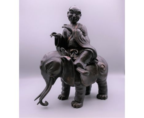 A Chinese bronze model of a gentleman seated on an elephant. 23.5 cm high.