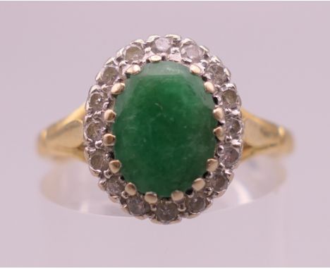 An 18 ct gold emerald and diamond ring. Ring size P/Q. 4.7 grammes total weight.