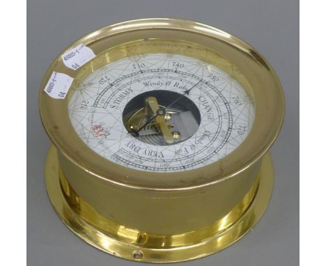 A brass barometer. 17.5 cm diameter.
