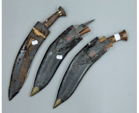 A bone inset wooden handled kukri in scabbard and two other kukris. The former 46.5 cm long.