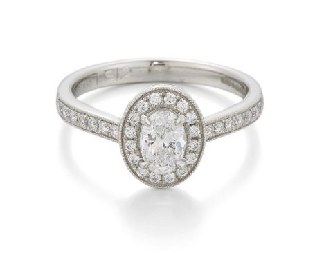 A PLATINUM DIAMOND CLUSTER RING an oval-cut diamond within a milgrain border of round brilliant-cut diamonds, to diamond-set 