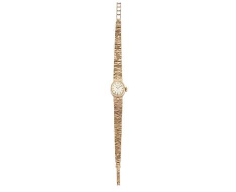 A 9 CARAT GOLD ROTARY BRACELET WATCH the oval silver dial with gilt baton index and hands, oval case 12mm by 8mm with bark fi
