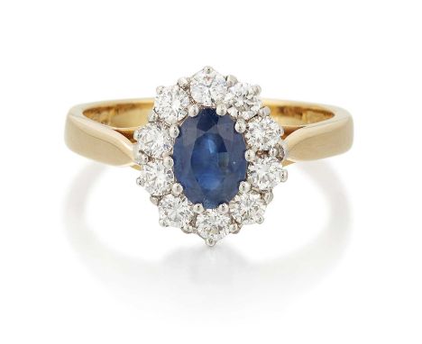 AN 18 CARAT GOLD SAPPHIRE AND DIAMOND CLUSTER RING an oval-cut sapphire within a border of round brilliant-cut diamonds. Esti