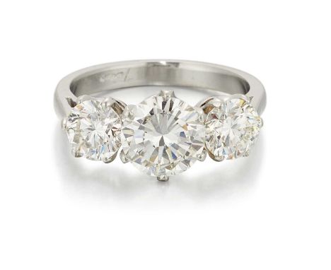 A PLATINUM DIAMOND THREE STONE RING graduated round brilliant-cut diamonds in claw settings, to tapering shoulders. Estimated