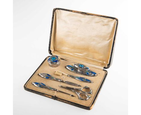 AN ART NOUVEAU SILVER AND ENAMEL MANICURE SET by Steinhart &amp; Co, Birmingham 1909, in Liberty style, cased. Nail buffer 10