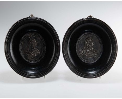 TWO EARLY 18TH CENTURY SILVER PORTRAIT PLAQUES of William III and Maria II, in ebonised oval framed. (2) Frames 19cm by 17cm