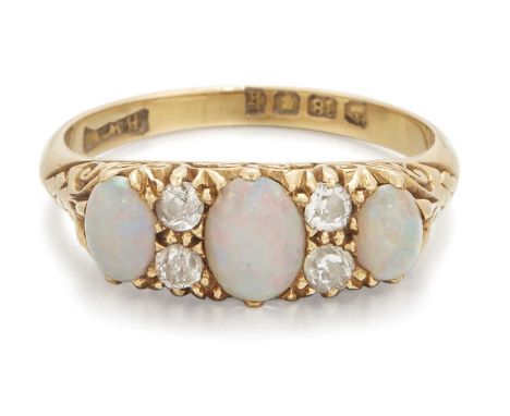 AN EDWARDIAN 18 CARAT GOLD OPAL AND DIAMOND RING three graduated oval opals spaced by pairs of old-cut diamonds, in a carved 