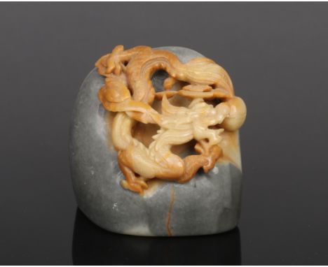 A Chinese carved soapstone boulder. Decorated in high relief with a scrolling dragon, 5.5cm. Good condition.