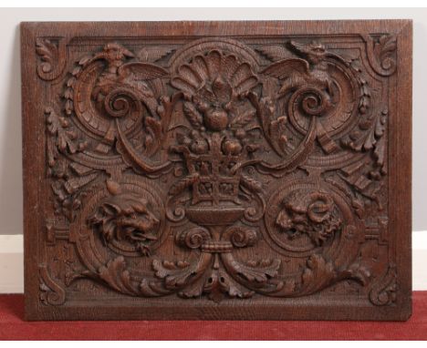 A late 17th / early 18th century carved oak panel. With a central basket containing fruit on a scroll, shell and acanthus gro