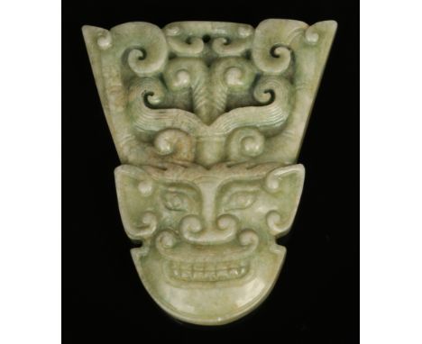 A Chinese carved jade coloured hardstone pendant formed as an archaistic mask, 8cm. Good condition.