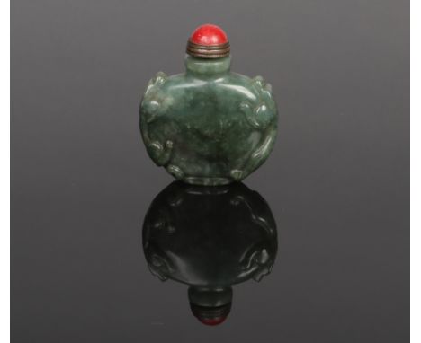 A Chinese carved jade snuff bottle. With a red hardstone stopper. Decorated with a pair of mythical beasts, one to each shoul