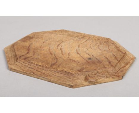 A Robert Thompson Mouseman oak cheese board of canted rectangular form. Carved with a mouse to the bevelled edge, 30.5cm wide