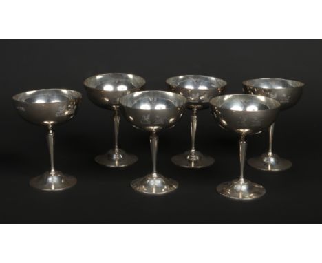 A set of six George V silver champagne saucers by Goldsmith's &amp; Silversmith's Co. Ltd. Engraved with three crests, a grif