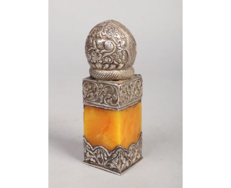 A 19th century Indian silver mounted butterscotch amber desk seal. The mounts with repousse decoration depict mythical beasts