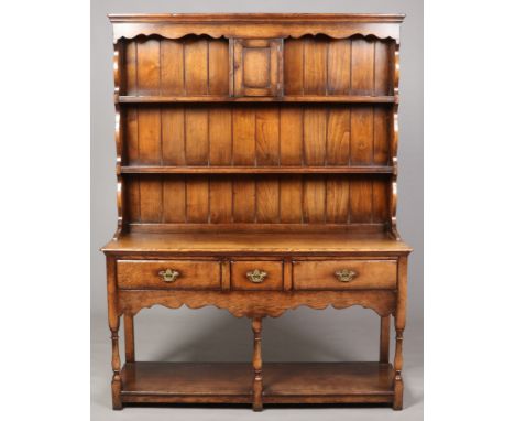 A Titchmarsh &amp; Goodwin oak dresser. With delft rack incorporating spice drawers and raised over a three drawer base with 