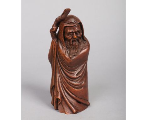 A Chinese carved bamboo figure of Shou Lao. Wearing a hooded flowing cloak and holding a gnarled staff, c.1900, 21cm. Good co