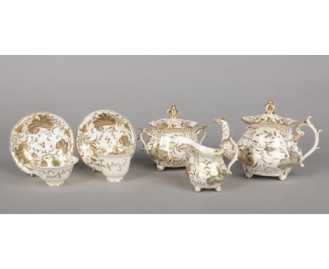 A Rockingham Neo-Rococo part tea service of three spur handle type with crown finials. Decorated with grey and gilt scrolls e