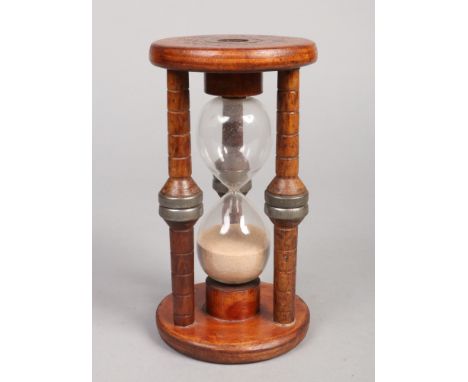 A vintage mill bobbin sandglass, with double blown hourglass bulb within a three pillar case. 15 minute timer, 23.5cm. Some s