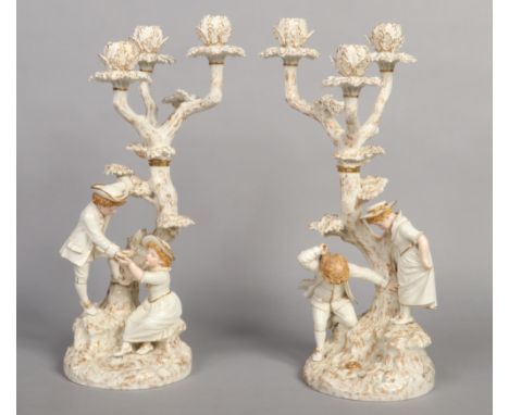 A superb pair of Royal Worcester Hadley style figural three branch candelabra. Each modelled as a tree with a naturalistic ba