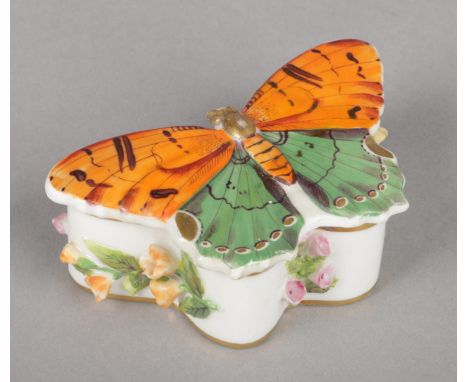 A Rockingham novelty trinket box and cover in the form of a butterfly. Painted to the top with green and orange enamels and a