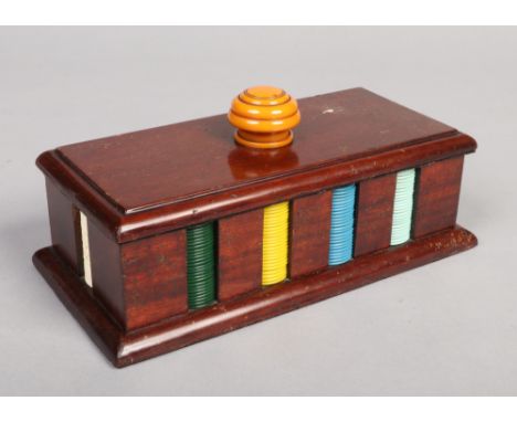 An Art Deco gaming counter caddy. With butterscotch catalin knop and ten denominations of Bakelite counters, 26cm. Good condi