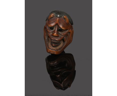 A rare Japanese Meiji period carved boxwood netsuke. Formed as a noh (theatre) mask with metal hair and eyes, 4.5cm. Good con