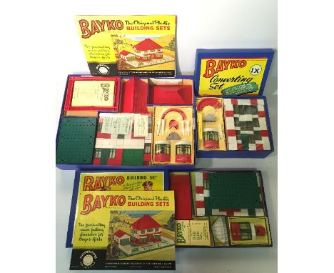 Three Bayko construction sets: No.0, parts include 2 x roof end no.29 and green base (appears E with small parts still wrappe