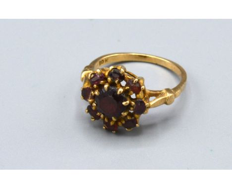 A 9ct Yellow Gold Cluster Ring set with garnets within a pierced setting, 2.7 gms Size M 