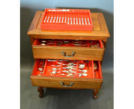 A Silver Plated Canteen of Cutlery housed within a Chinese hardwood four drawer chest with brass handles raised upon cabriole