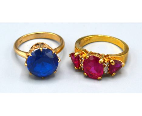 A 10ct. Gold Dress Ring set three red stones, ring size O, 4.6 gms. together with a 9ct. gold dress ring set large blue stone