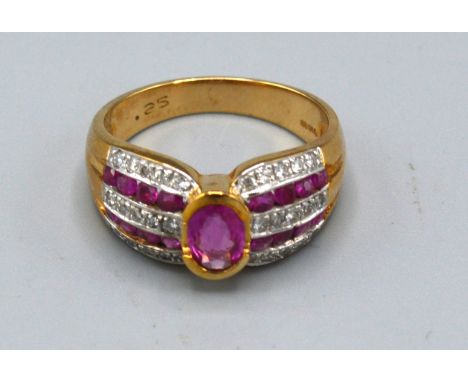A 9ct. Gold Ruby and Diamond Ring with central oval ruby flanked by bands of rubies and diamonds, ring size L, 4.3 gms. 