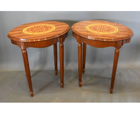 A Pair of French marquetry inlaid oval lamp tables each with an oval marquetry inlaid moulded top above a shaped frieze raise
