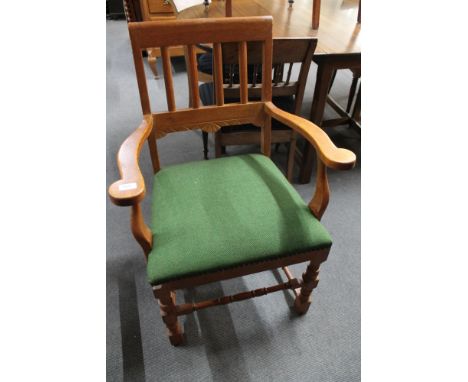 A light oak armchair in green upholstery. 