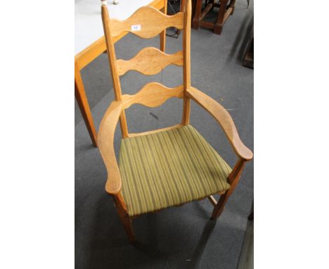 A light oak armchair with green striped fabric. 