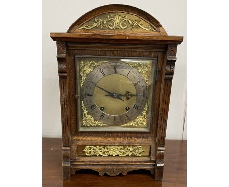 Late 19th/early 20th century mantel clock in an oak case with brass &amp; silvered dial with brass spandrels &amp; mounts Ht 
