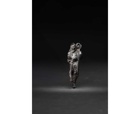 A TALL JAPANESE KUROGAKI WOOD NETSUKE OF A SENNINEDO PERIOD, 19TH CENTURYThe gaunt figure depicted standing on one leg, lifti