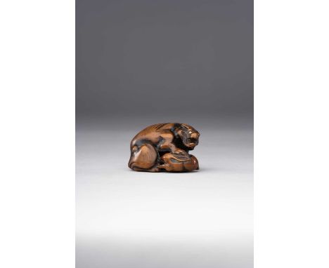 λ A JAPANESE WOOD NETSUKE OF A WOLF OR YAMA-INU (WILD DOG) WITH RABBITEDO PERIOD, 18TH/19TH CENTURYSeated on its haunches wit