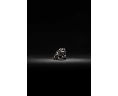 A JAPANESE DARK WOOD NETSUKE OF A SHISHIMEIJI ERA, 19TH CENTURYThe lion dog is depicted seated on its haunches, baring its te